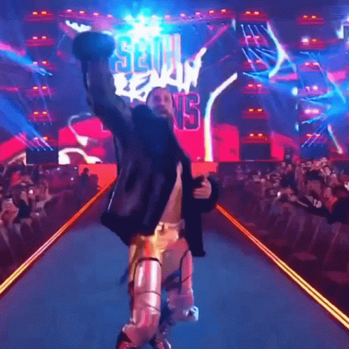 Wrestler Walking Down Ramp Arms Up Seth Reigns Sign GIF