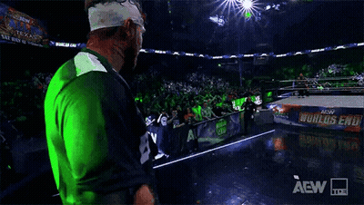 Wrestler Walking On Stage In Green And Blue Jersey GIF