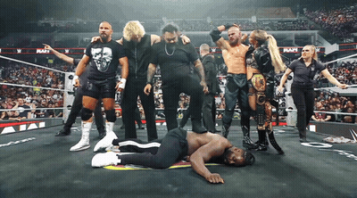 Wrestlers Standing Around Wrestler Laying On Ground GIF