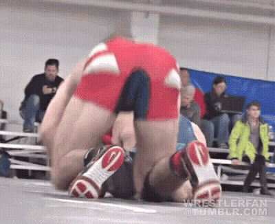 Wrestlers Wrestling On Mat With Crowd Watching GIF