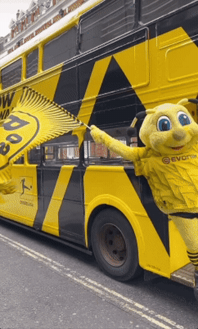 Yellow And Black Double Decker Bus With Mascot GIF