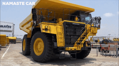 Yellow Dump Truck Parked In Front Of Building Saying Matsu GIF