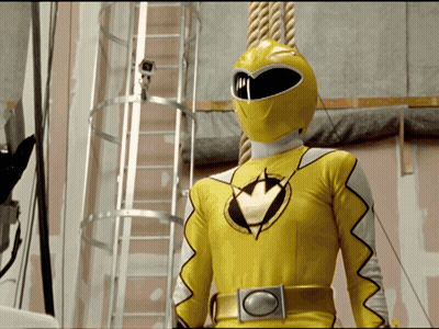 Yellow Power Ranger Standing In Front Of Camera GIF