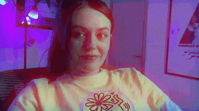 Yellow Shirt Woman With Flower Looking At Camera GIF