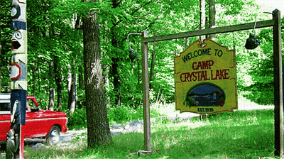 Yellow Sign Saying Welcome To Camp Crystal Lake GIF
