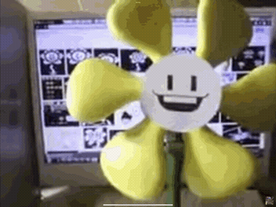 Yellow Smiley Flower in Front of Computer Screen