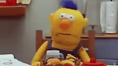 Yellow Stuffed Animal At Table With Hamburger And Coffee GIF