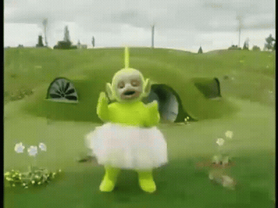 Yellow Teletubbies In White Tutu Standing In Field GIF