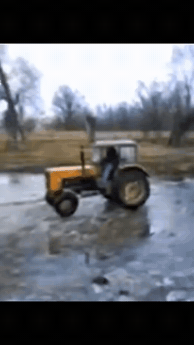 Yellow Tractor Driving Through Frozen Field GIF