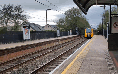 Yellow Train Pulling Into Station With No Smoking Sign GIF