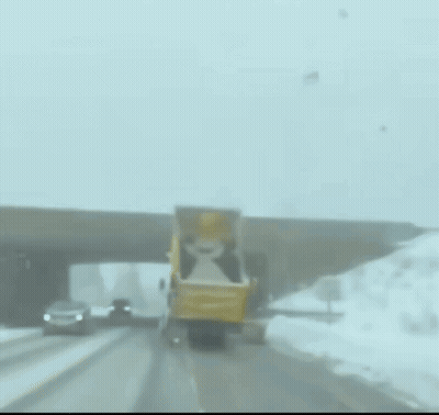 Yellow Truck Driving Down Snowy Road GIF