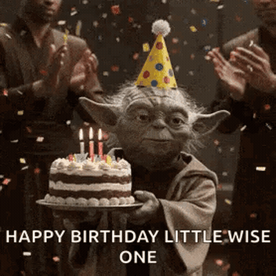 Yoda Is Holding A Birthday Cake With Candles And A Party Hat . GIF