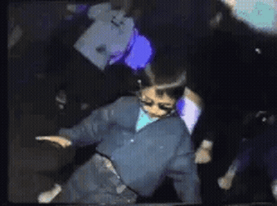 Young Boy Dancing In Dark Room With Crowd GIF