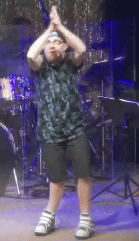 Young Boy Dancing in Front of Drum Kit