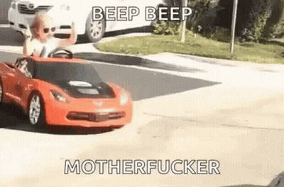 Young Boy Driving Toy Car Down Street GIF
