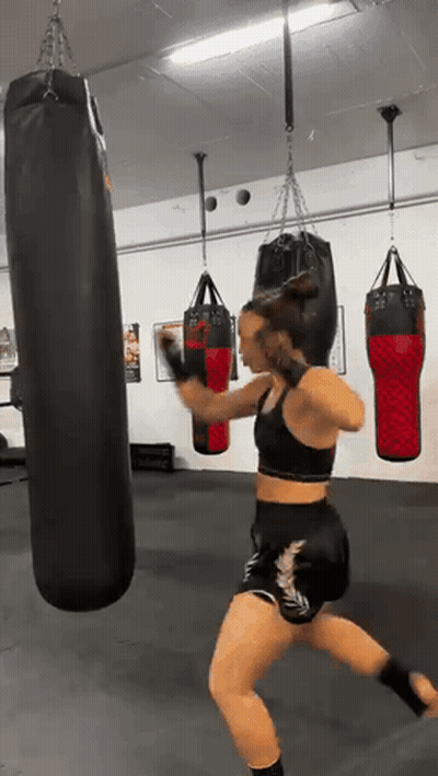 Young Boy Hitting Red Punching Bag With Boxing Gloves GIF