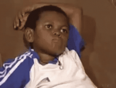 Young Boy In Blue And White Shirt On Couch GIF