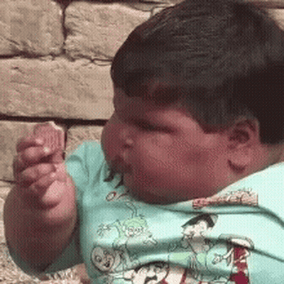 Young Boy In Blue Cartoon Shirt Eating Food GIF