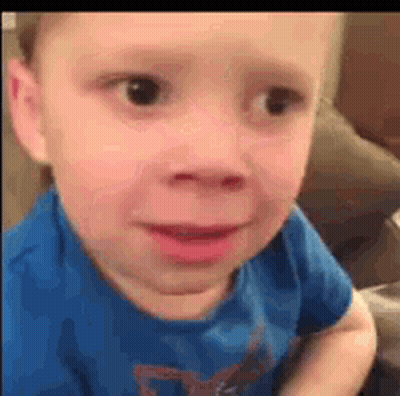 Young Boy In Blue Shirt Making Funny Face On Couch GIF