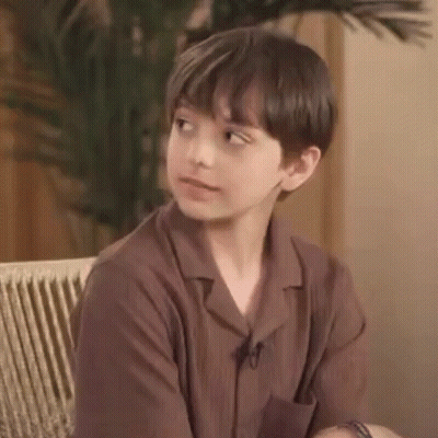 Young Boy In Brown Shirt Making Funny Face On Couch GIF