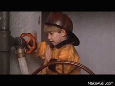 Young Boy In Fireman Hat Holding Valve GIF