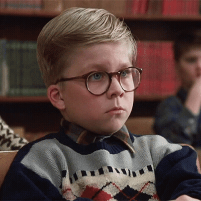 Young Boy In Glasses And Plaid Sweater Sitting In Classroom GIF