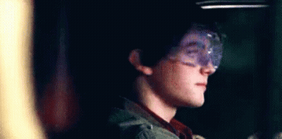 Young Boy In Goggles Smiling In Dark Room GIF
