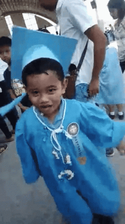 Young Boy In Graduation Cap And Gown GIF