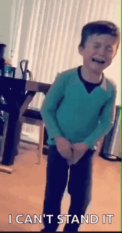 Young Boy In Green Sweater Standing With Hands In Pockets GIF