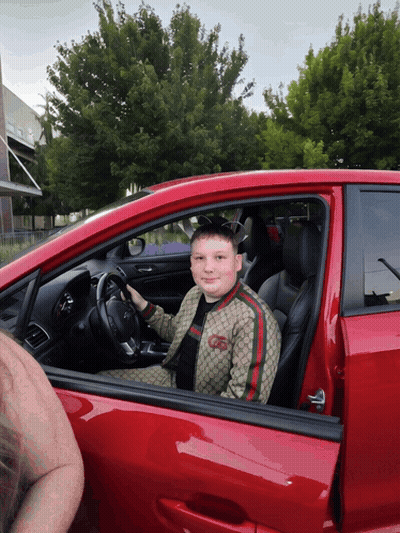 Young Boy In Gucci Jacket Sitting In Red Car GIF