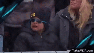 Young Boy In Hat With M Sitting Next To Woman GIF