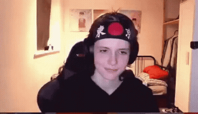 Young Boy In Headband With Red Circle Sitting At Computer GIF