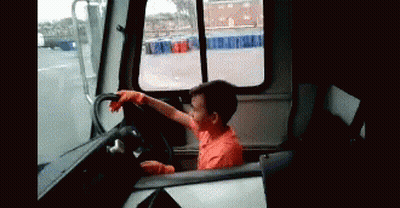 Young Boy In Orange Shirt Driving Truck GIF