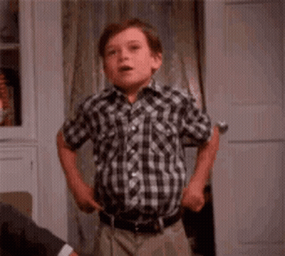 Young Boy In Plaid Shirt Making Funny Face At Door GIF