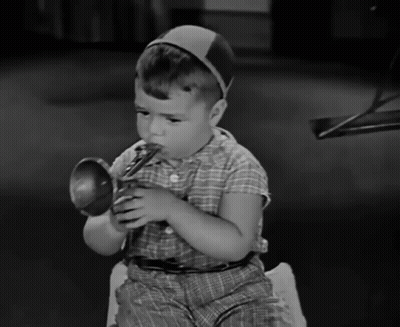 Young Boy In Plaid Shirt Playing Toy Trumpet GIF