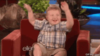Young Boy In Plaid Shirt Sitting In Red Chair With Arms Up GIF