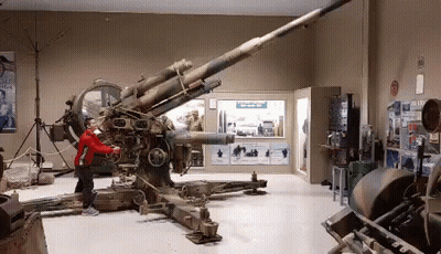 Young Boy In Red Jacket In Front Of Cannon GIF