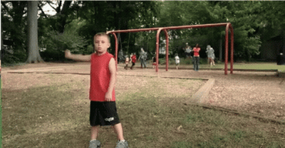 Young Boy In Red Shirt And Black Shorts In Park GIF