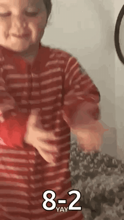 Young Boy In Red Striped Shirt Holding Red Object GIF