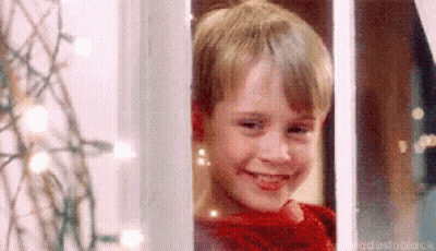 Young Boy In Red Sweater Smiling Out Window GIF