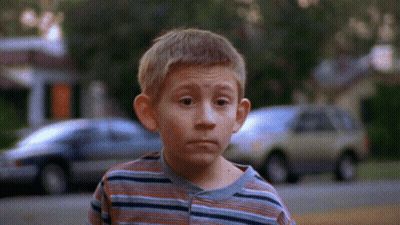 Young Boy In Striped Shirt With Cars Background GIF