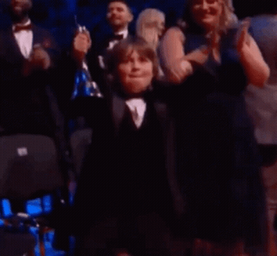 Young Boy in Tuxedo Applauded by Crowd