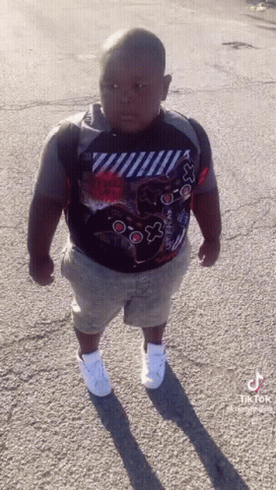 Young Boy In Video Game Controller Shirt On Street GIF