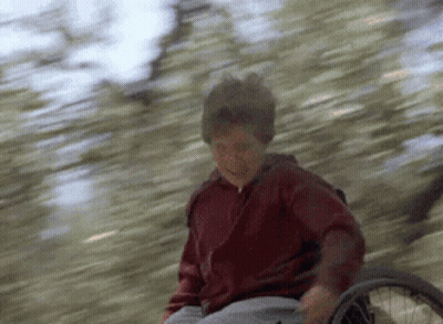 Young Boy In Wheelchair Riding Down Hill GIF