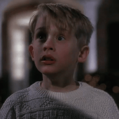 Young Boy In White Sweater Looking At Camera GIF
