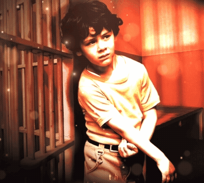 Young Boy Leaning Against Wooden Fence With Th GIF