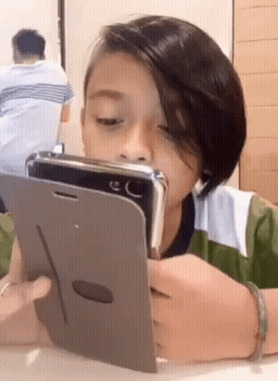 Young Boy Looking At Cell Phone GIF