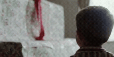 Young Boy Looking At Christmas Present GIF