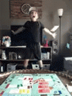 Young Boy Looking At Falling Monopoly Money GIF