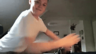Young Boy Playing Video Game In White Shirt GIF